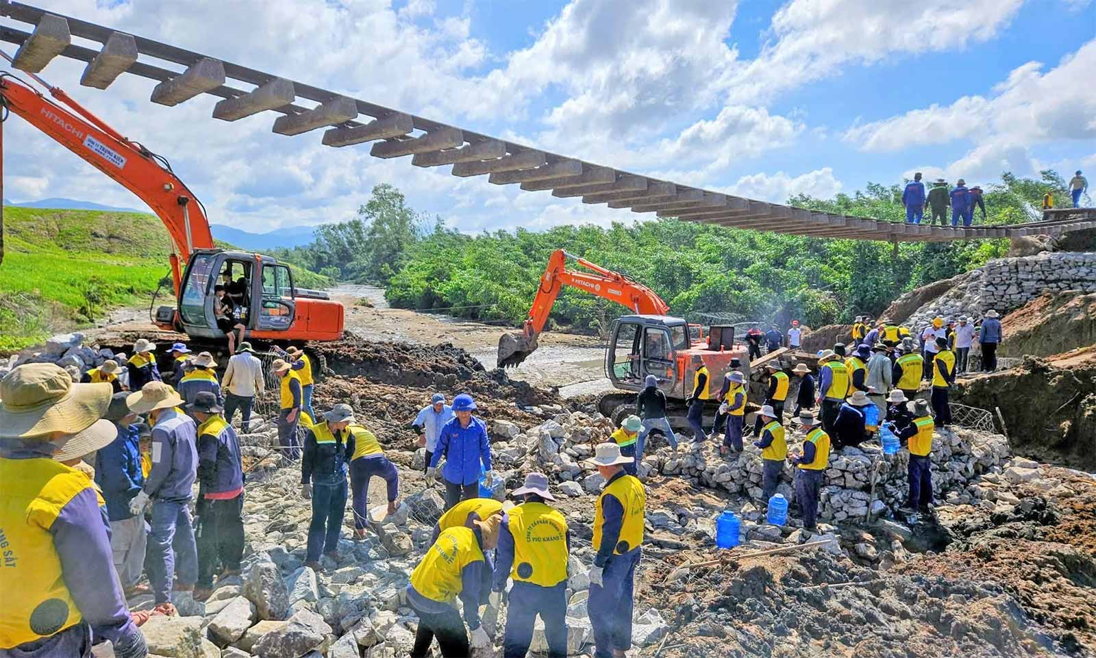 Ngay sau khi nước rút, hàng trăm công nhân cùng nhiều máy xúc, xe tải, rọ đá và vật liệu được huy động để phục hồi nền đường.